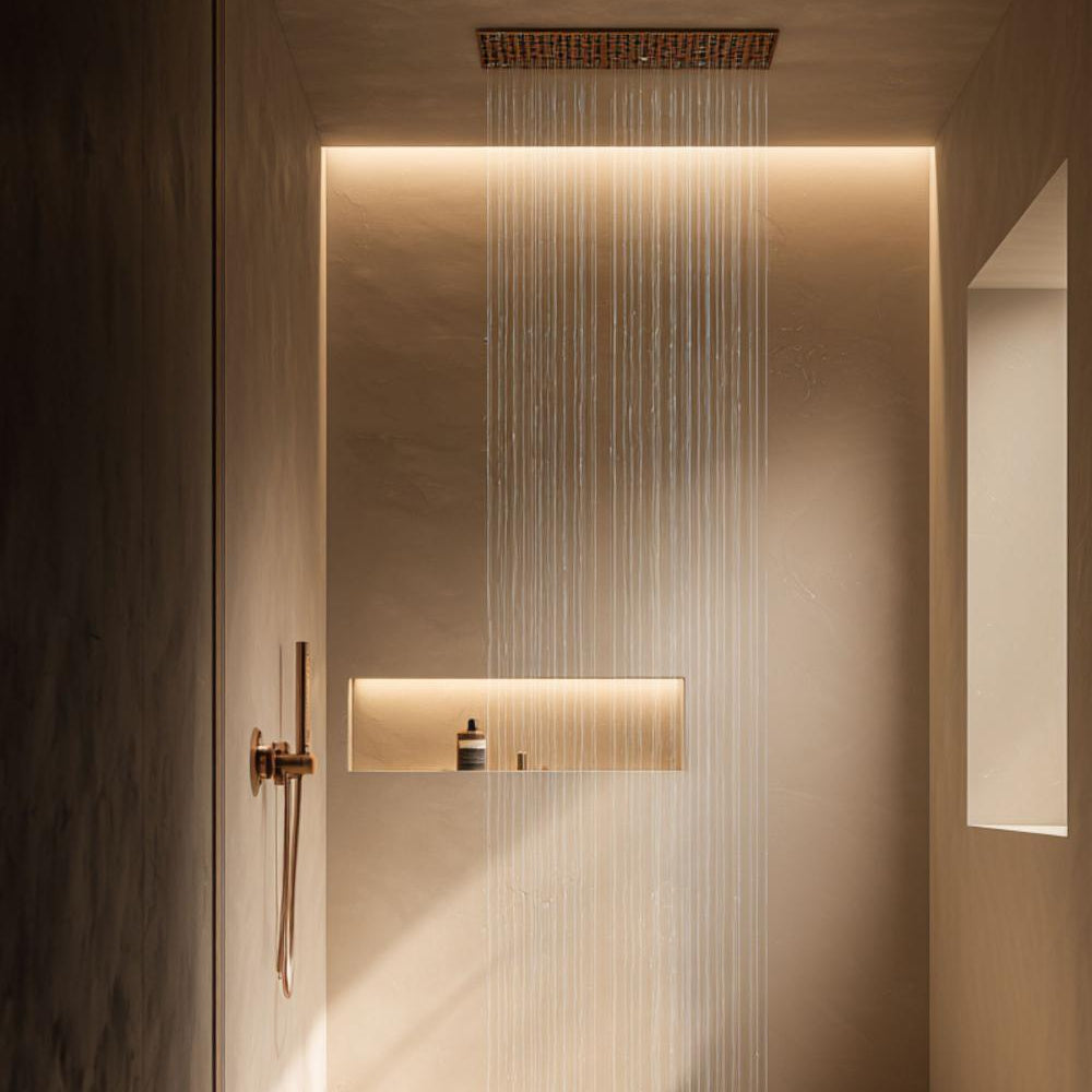 Contemporary luxury spa shower with ceiling-mounted rainfall showerhead, warm stone surfaces, and integrated lighting